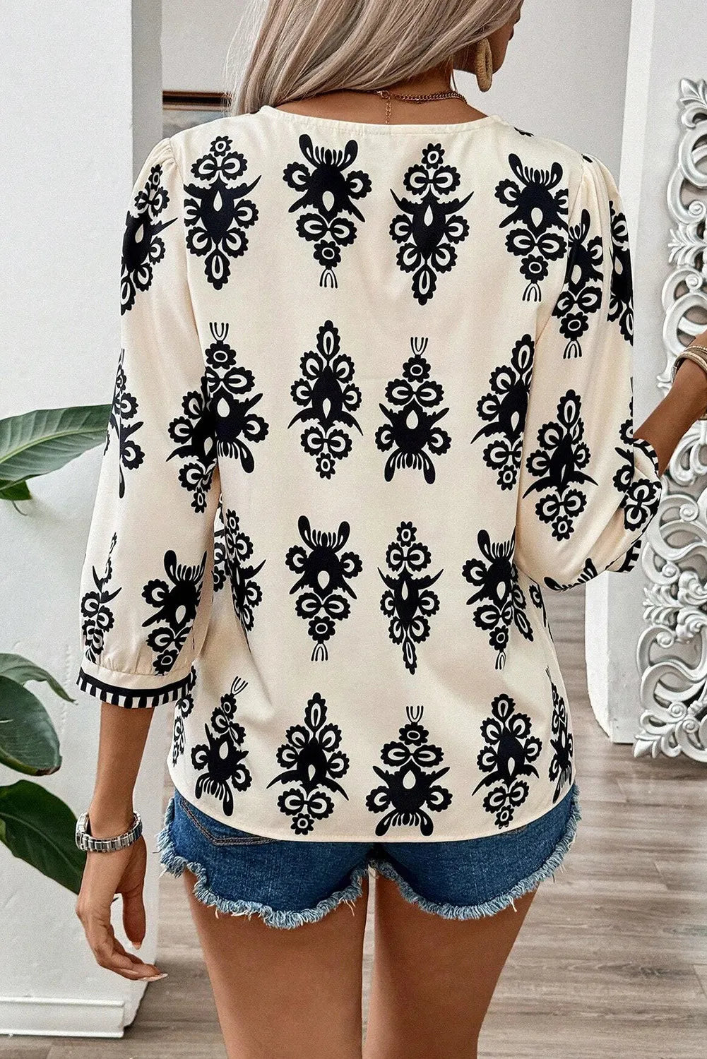 Blusa estampada con escote en V y mangas tres cuartos