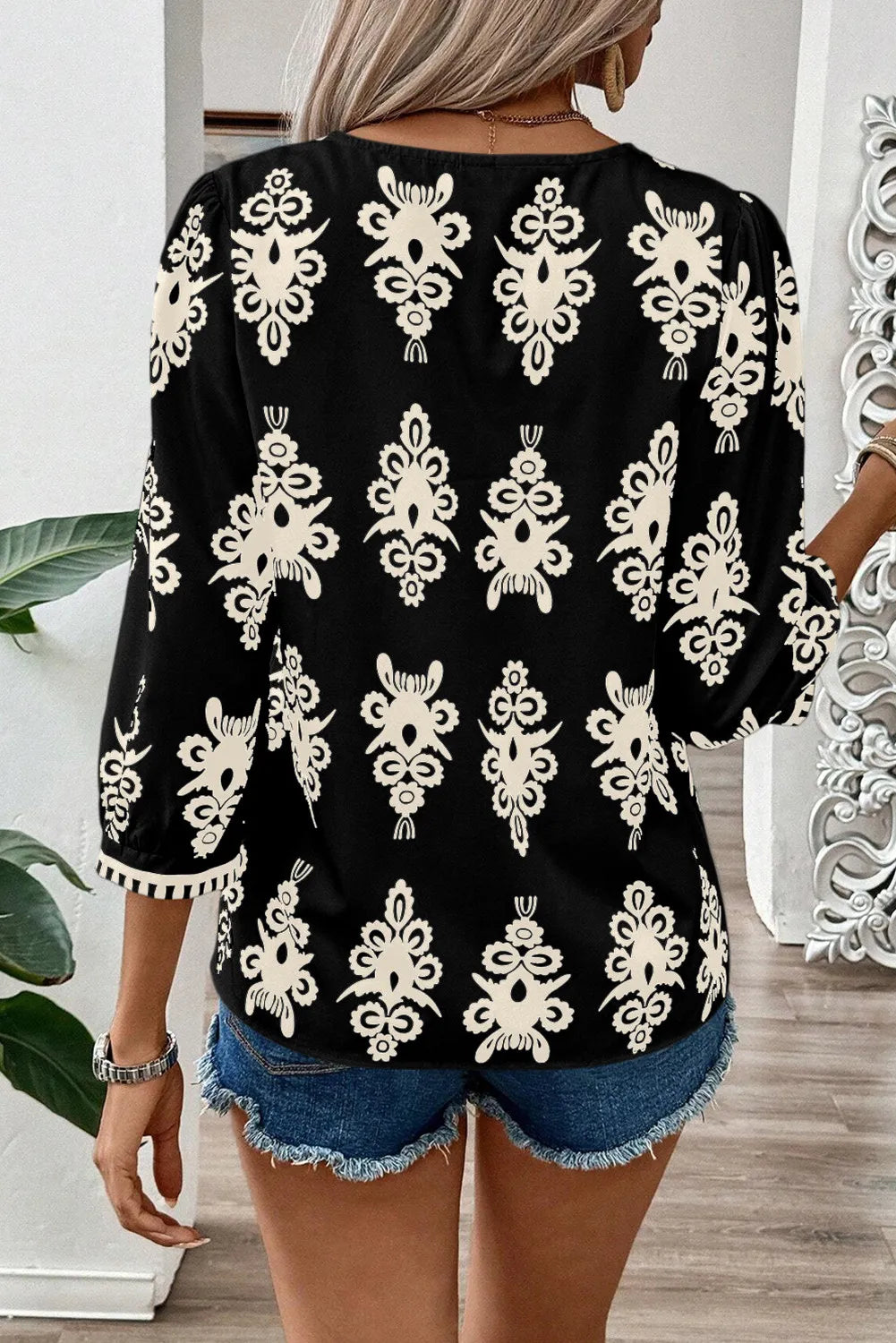 Blusa estampada con escote en V y mangas tres cuartos