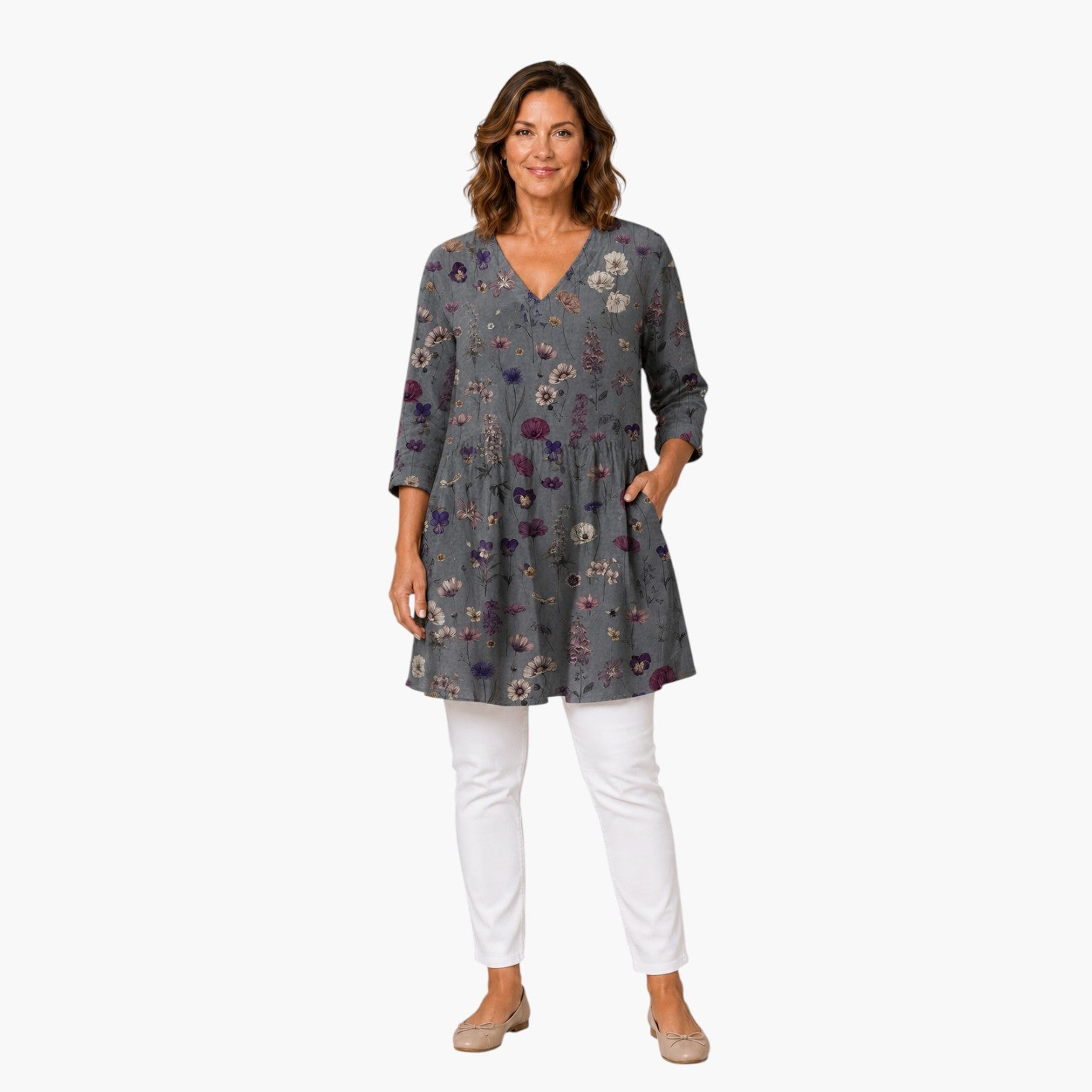 Model draagt My Store 4 Addison blouse met V-hals, lange mouwen en een grijs bloemenpatroon gecombineerd met witte broek