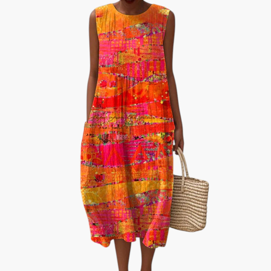 My Store 4 Faye Sunset midi-jurk met kleurrijk patchwork-patroon in oranje, roze en geel op een strand.