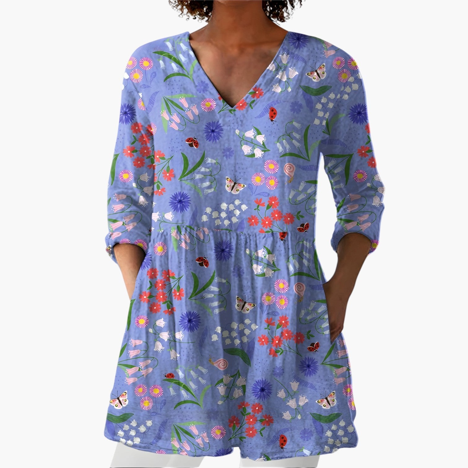 My Store 4 Josie lange blouse met V-hals, blauwe stof met kleurrijk bloemen- en insectenpatroon en zakken.