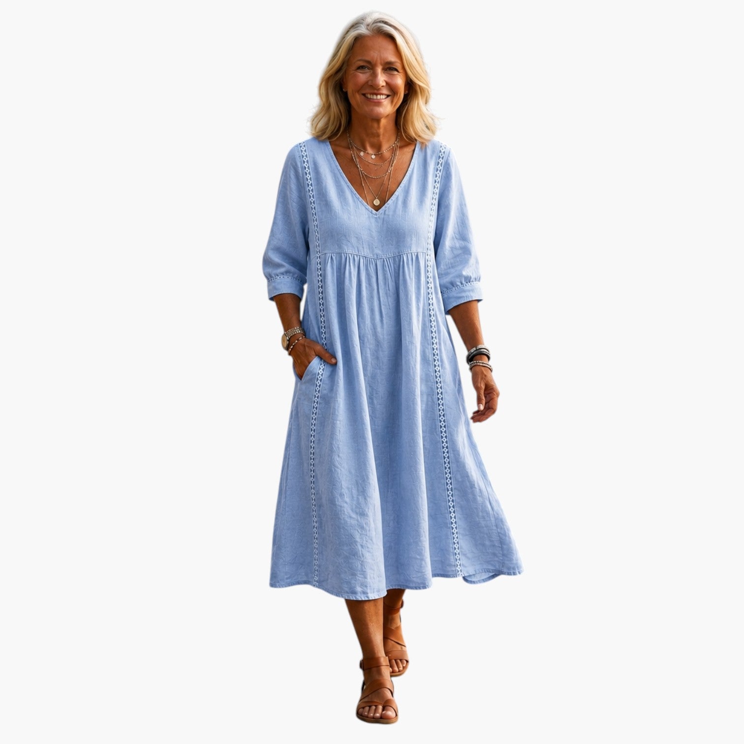 Vrouw draagt een lichtblauwe My Store 4 maxi-jurk met V-hals en driekwartmouwen tijdens een wandeling bij het water.