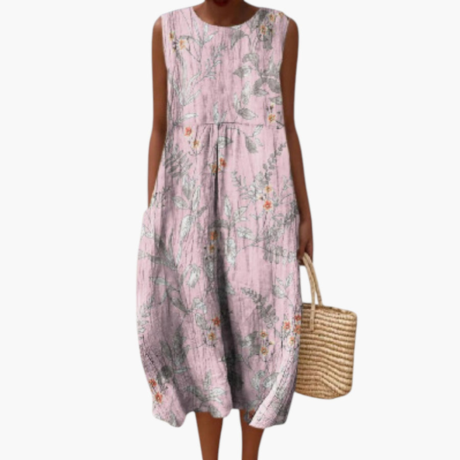 My Store 4 Nora botanische midi-jurk in zachtroze met bloemenprint, mouwloos model op het strand met rieten tas