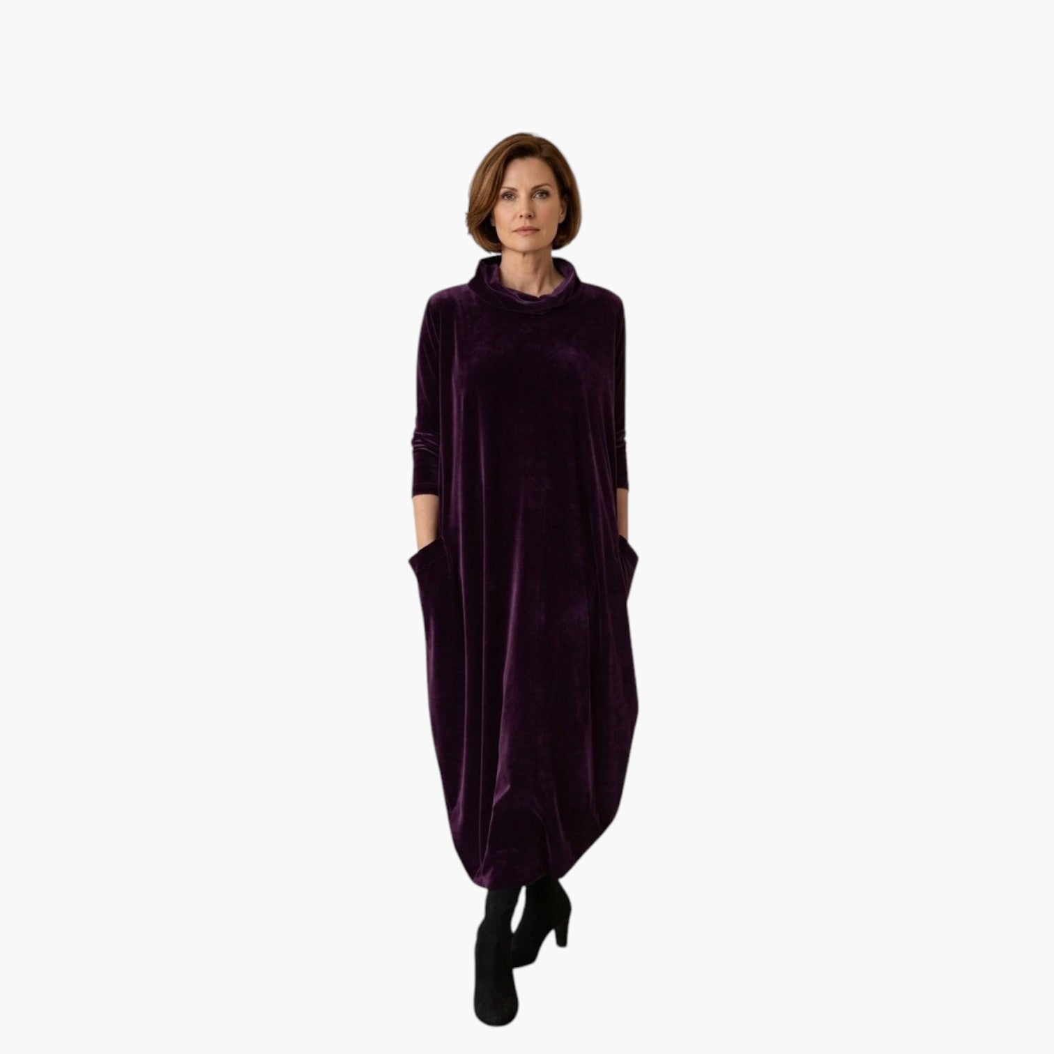 Vrouw draagt een paarse My Store 4 Leona fluwelen maxi-jurk met opstaande kraag en zakken in een minimalistisch interieur